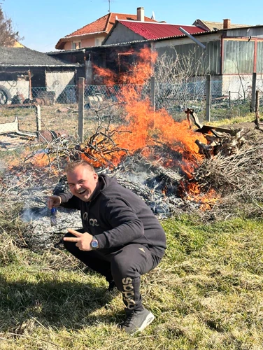 Nevető kolléga az égő avar előtt